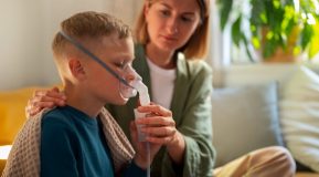 Mother caring for her il son who is using a nebuliser. Employment Law changes in April