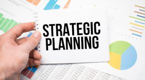 The text Strategic Planning written on a notepad and financial documents