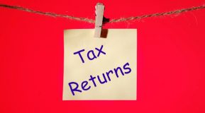 Tax returns text on a yellow sticker on a rope with clothes pins on a red background source-FreePik Premium